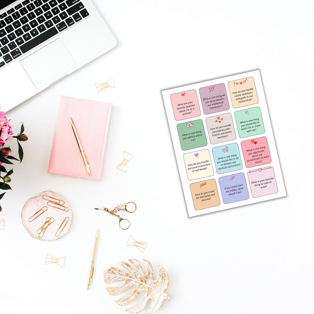 a desk with a laptop, flowers and a planner