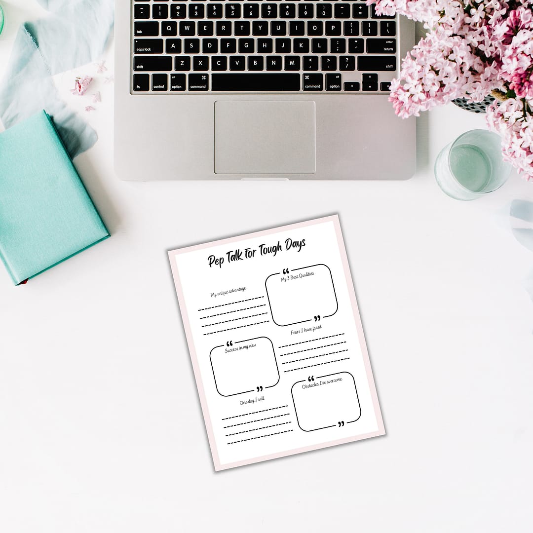 A laptop rests on a white surface beside a green notebook, pink flowers, and a motivational worksheet titled "Pep Talk for Tough Days," ideal for The Glow Getter who is ready to seize every opportunity.