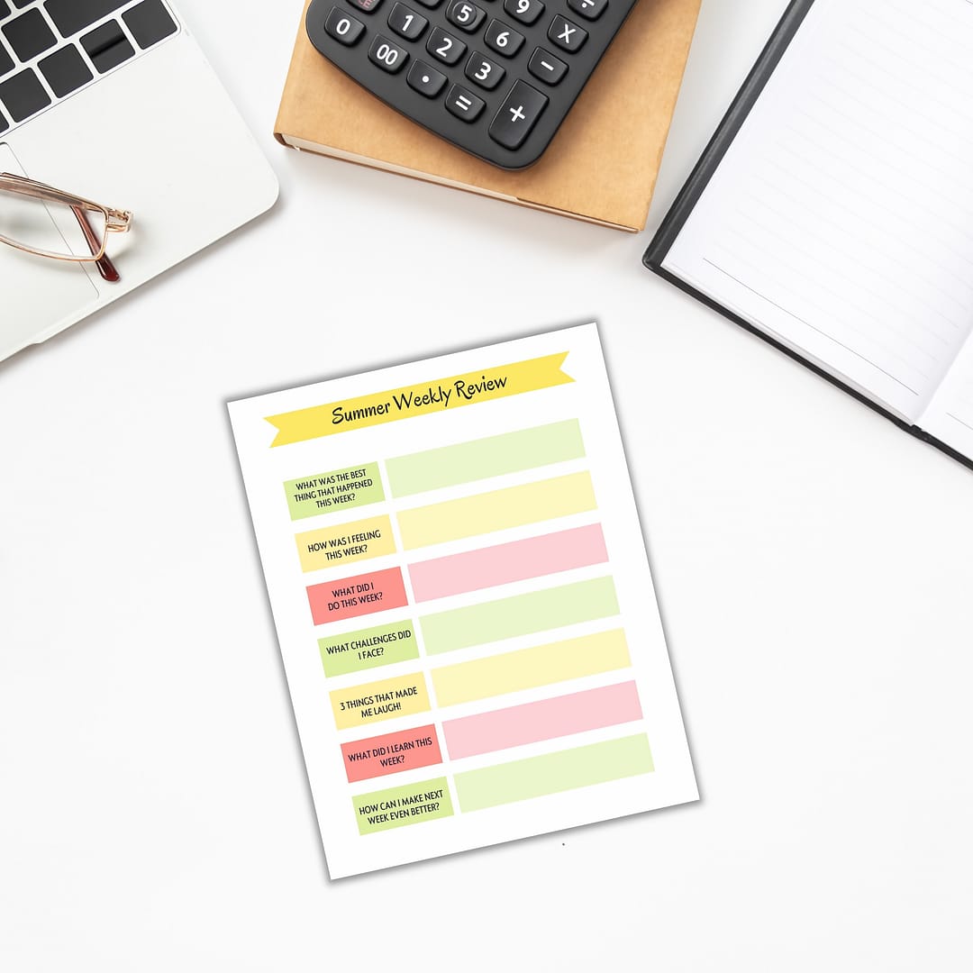 An overhead view of a desk displays a laptop, calculator, glasses, and notebook. The "Summer Planner for Kids" features a "Summer Weekly Review" sheet filled with prompts that embody the spirit of organizing children's activities and more.